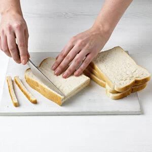 Cutting off the crusts from slices of white bread