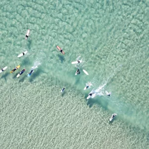 crystal clear waters with surfers seen from above