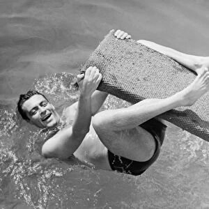 Man hanging on diving board (B&W), elevated view