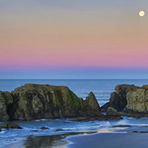 Full moon over sea stacks on beach at sunset, Bandon, Oregon, USA