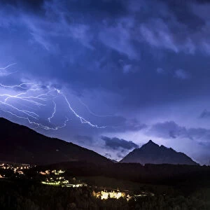 Ominous clouds and lightning bolts from thunderclouds over the Stubai Valley near Innsbruck, in the back Mt. Serles and Aldrans and Lans villages, night scene, Innsbruck, Tyrol, Austria, Europe