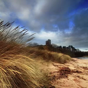 Ruined castle in sand dunes shore