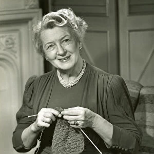 Smiling woman knitting