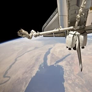 The aft section of the docked space shuttle Discovery and the stations robotic Canadarm2