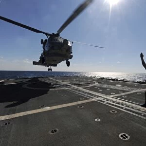 Boatswains Mate signals the pilots of an SH-60B Sea Hawk helicopter