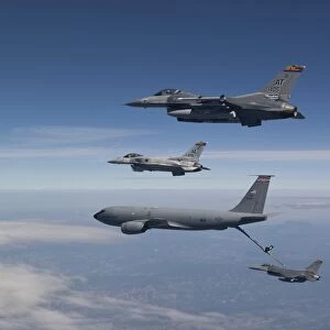 Four F-16s and a KC-135 fly in formation over Arizona