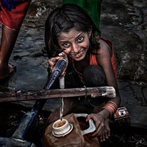 Rohingya refugee girl filling a container of water - Bangladesh