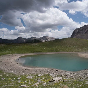 Alpine lake at an altitude of 2400 m, drying up during heatwave in summer, Lac des Rouites, Queyras, The Alps, France. 4th July, 2022