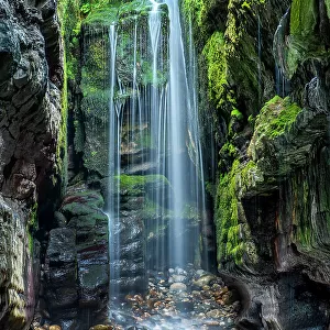 Waterfall in secluded coastal cave, near Largy, County Donegal, Ireland. September. 2021