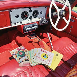 1960 Jaguar XK150 interior with record player and 7inch vinyl discs Creator: Unknown