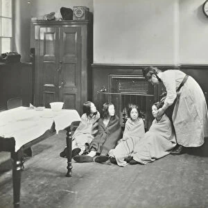 Girls drying their hair by the fire after a bath, Chaucer Cleansing Station, London, 1911