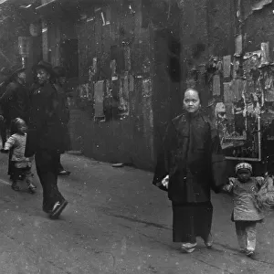 Woman and a child walking down a street, Chinatown, San Francisco, between 1896 and 1906. Creator: Arnold Genthe