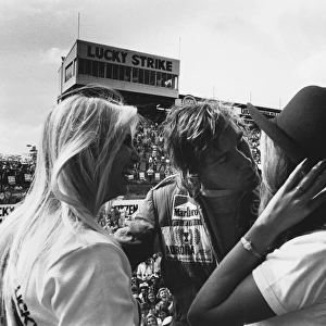 1976 South African Grand Prix: James Hunt, 2nd position, celebrates on the podium with some girls, portrait