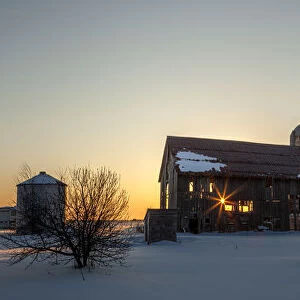 Dilapidated bard at sunrise in winter