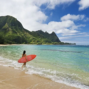 Hawaii, Kauai, Haena Beach Tunnels Beach, Woman Entering Ocean With Surfboard