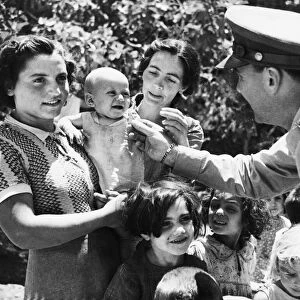 Allied soldiers meet Sicilian refugees during Second World War. 8th August 1943