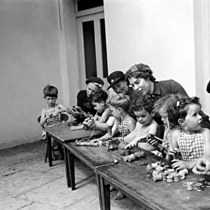 Children playing with cotton reels at Hollyshaw Residential Nursery