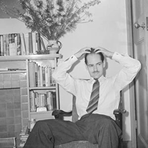 Peter Haigh 28 youngest of the BBC TV announcers, seen here at home applying hair