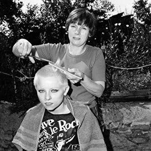 Punk girl Julie Brandon having her hair cut by her mother at their home in Thame