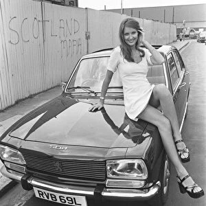 Reveille model Beulah Hughes seen here posing with a Peugeot 504 car which is a top prize