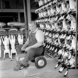 Toy tester: Man sitting on toy tractor at the Tri-ang factory in Merton South London 1965