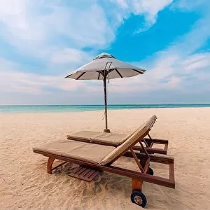Beautiful tropical sunset scenery, two sun beds, loungers, umbrella. White sand, sea view with horizon, colorful twilight sky, calmness and relaxation