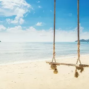 Wooden swing chair hanging on tree near beach at island in Phuket, Thailand. Summer Vacation Travel and Holiday concept