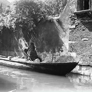 A builder working on a canal in Venice