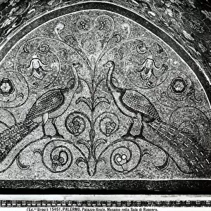 Two peacocks facing each other next to a shoot. Norman mosaic inside the Room of King Roger, in the Royal Palace (or of the Normans), Palermo