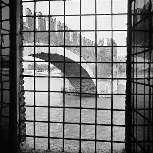 Ponte Scaligero of Verona seen through the grate of a window